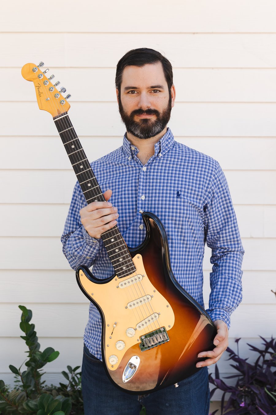 Abe Alam holding his Fender Stratocaster